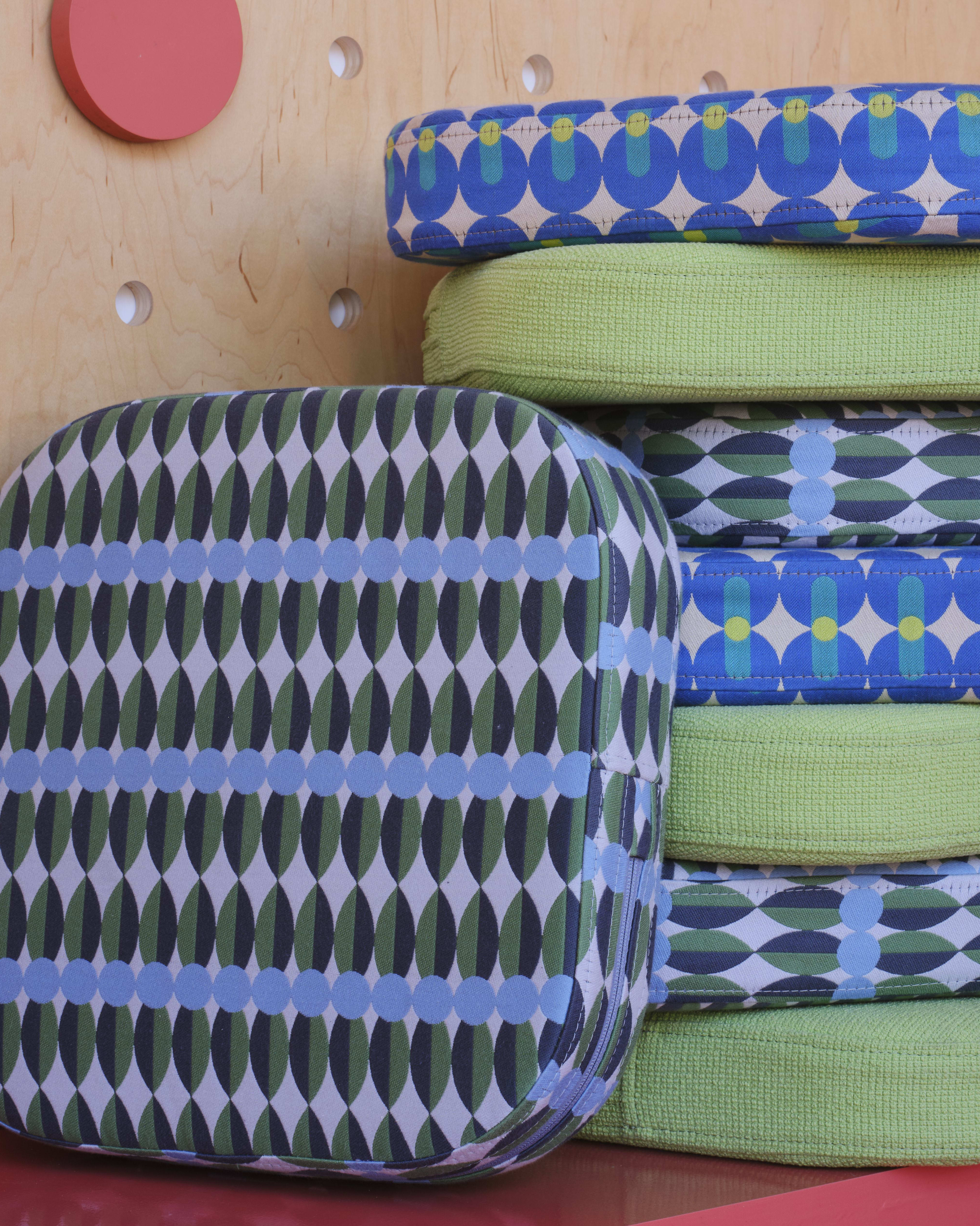 Close-up view of bolster cushions upholstered in Yinak Ilori textiles.