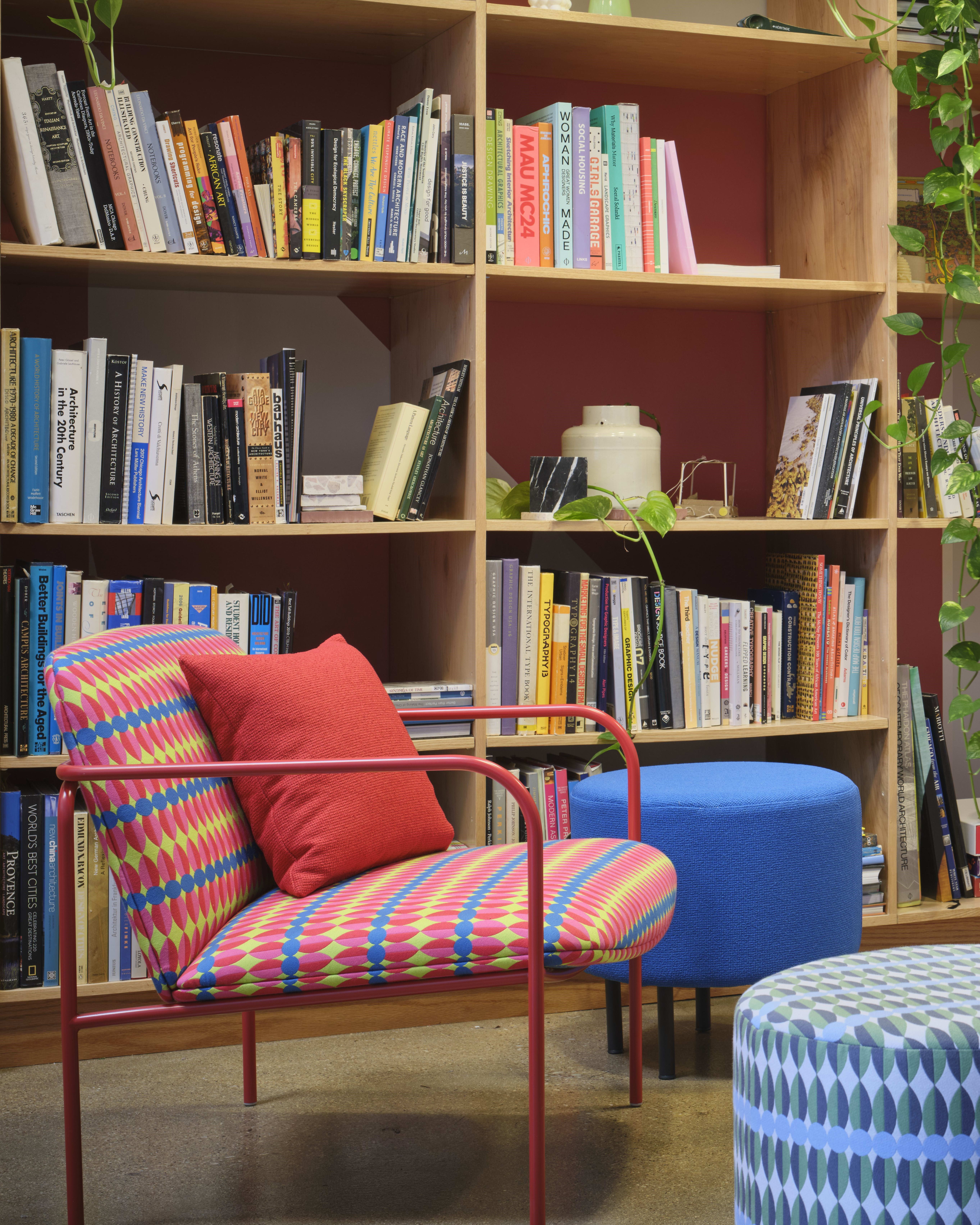 A library nook comes alive with eye-catching Yinka Ilori textiles uphosltered chair and seating stools.